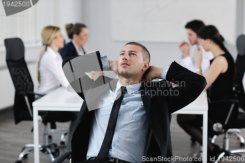 Image of Portrait of a handsome young business man with colleagues in bac