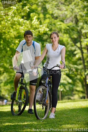 Image of Happy couple ridine bicycle outdoors