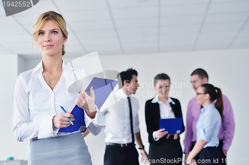 Image of business woman standing with her staff in background
