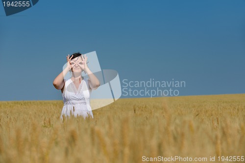 Image of young woman in wheat field at summer