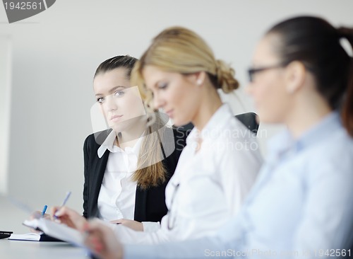 Image of business woman standing with her staff in background