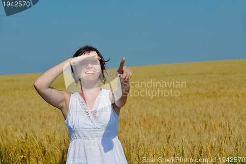 Image of young woman in wheat field at summer