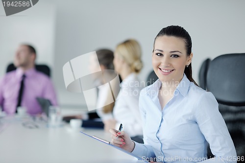 Image of business woman standing with her staff in background