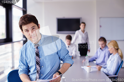 Image of business man  on a meeting in offce with colleagues in backgroun