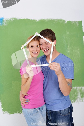 Image of happy couple paint wall at new home