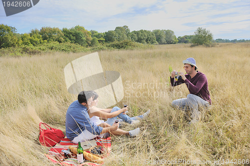 Image of happy couple enjoying countryside picnic in long grass