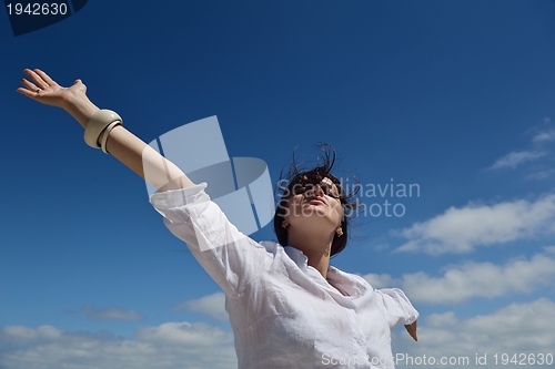 Image of young woman with spreading arms to sky