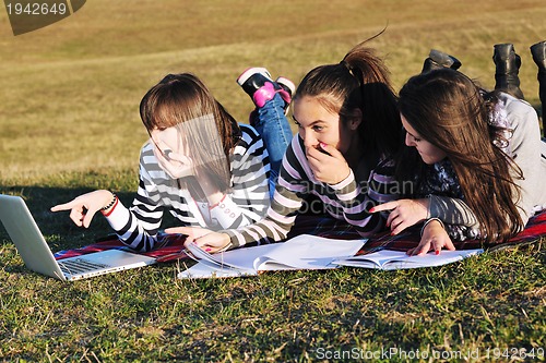Image of group of teens working on laptop outdoor