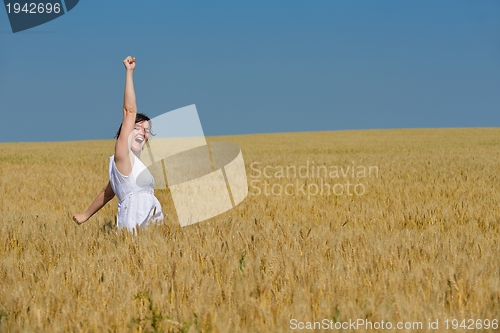 Image of young woman in wheat field at summer
