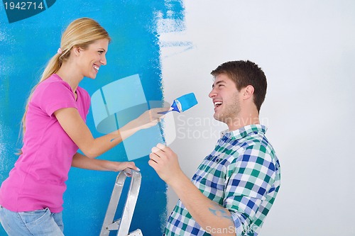 Image of happy couple paint wall at new home