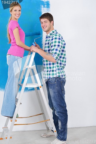 Image of happy couple paint wall at new home