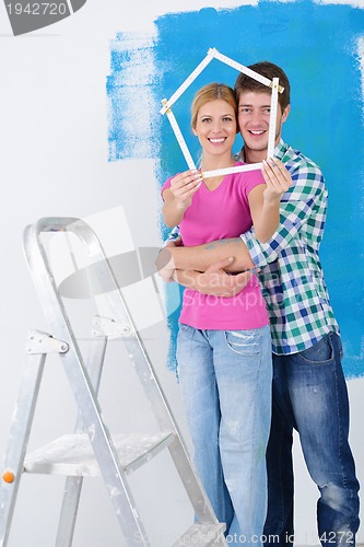 Image of happy couple paint wall at new home