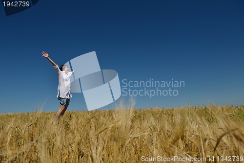 Image of young woman in wheat field at summer