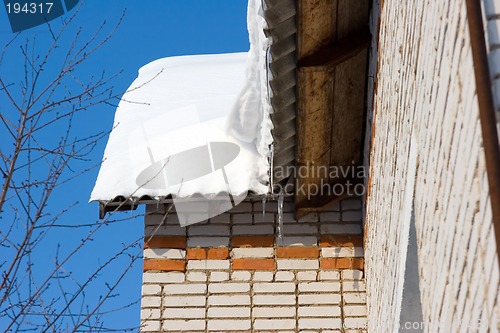 Image of Snow covered roof with icicles