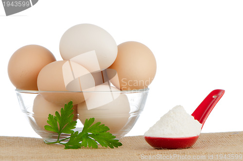 Image of Brown eggs on brown and red ceramic spoon with white powder