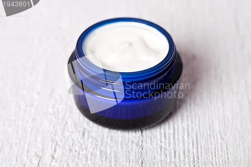 Image of face cream in blue jar 