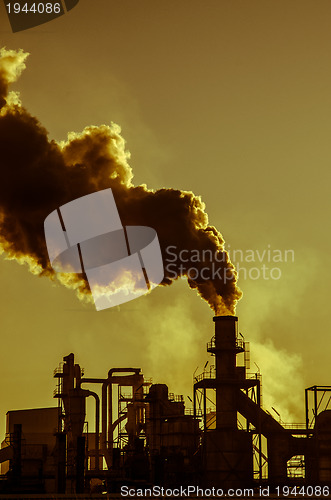 Image of Smoking chimney  at sunset 
