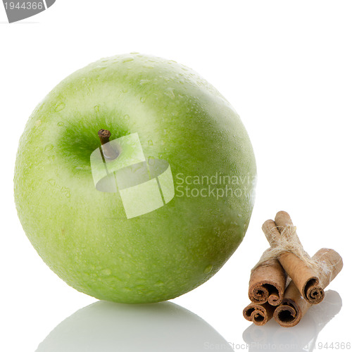 Image of Ripe green apple with cinnamon sticks