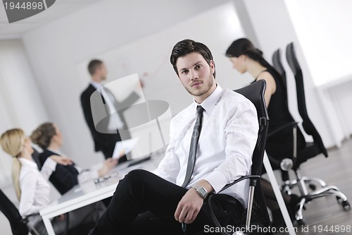 Image of handsome young business man with colleagues in background