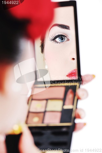 Image of beautiful young woman applying makeup