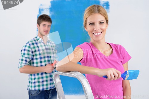 Image of happy couple paint wall at new home