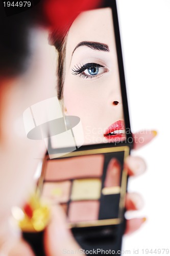 Image of beautiful young woman applying makeup