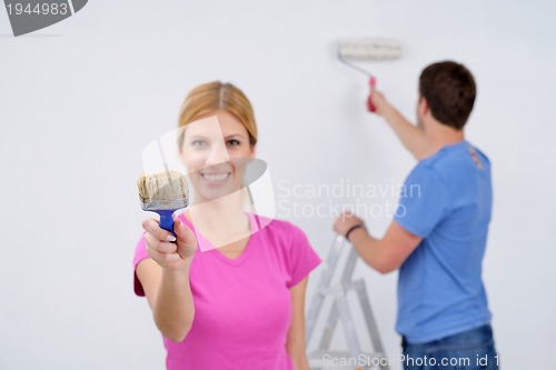 Image of happy couple paint wall at new home