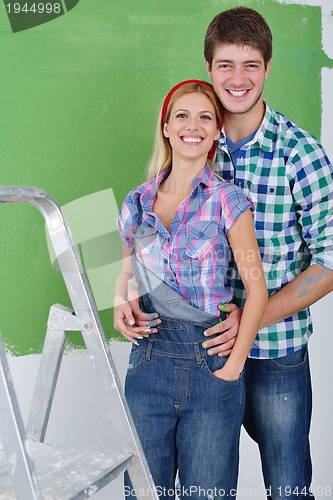 Image of happy couple paint wall at new home