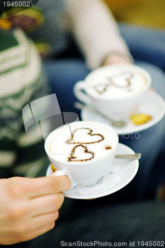 Image of Young romantic couple relax on sofa in front of fireplace at hom