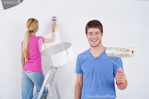 Image of happy couple paint wall at new home