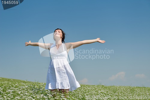 Image of Young happy woman in green field