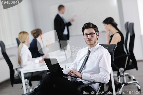 Image of Portrait of a handsome young business man with colleagues in bac
