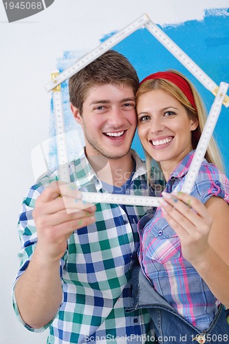 Image of happy couple paint wall at new home