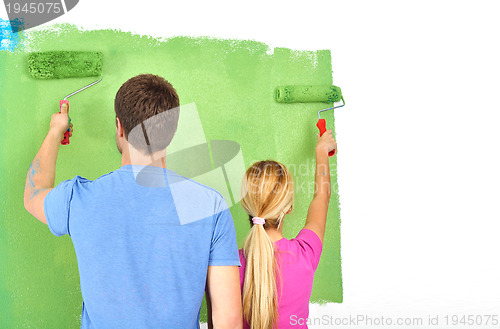 Image of happy couple paint wall at new home