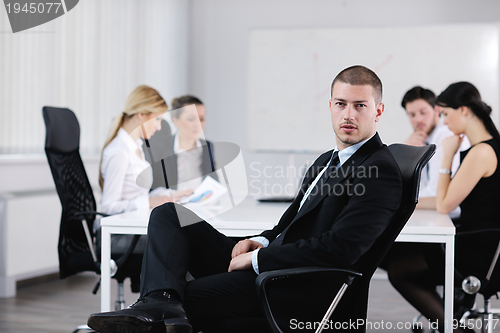 Image of Portrait of a handsome young business man with colleagues in bac