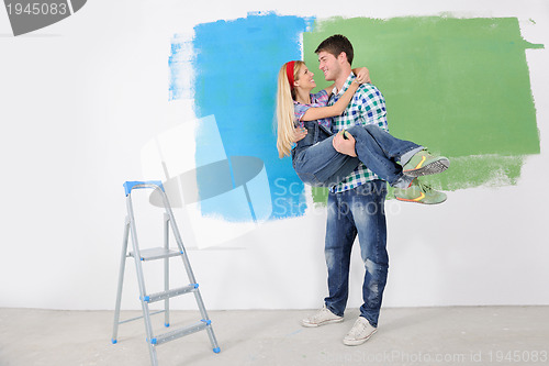 Image of happy couple paint wall at new home