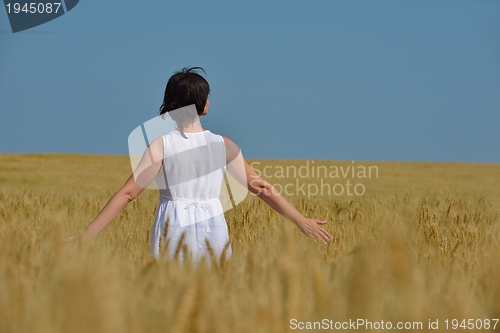 Image of young woman in wheat field at summer
