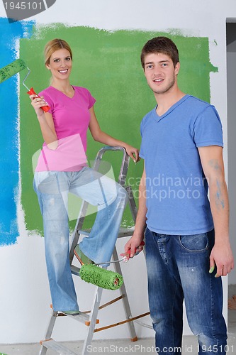 Image of happy couple paint wall at new home