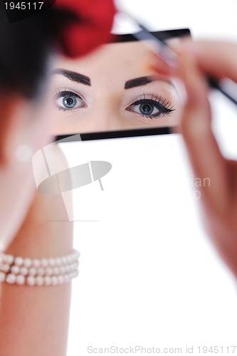 Image of beautiful young woman applying makeup