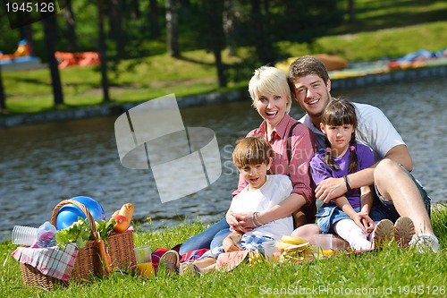 Image of Happy family playing together in a picnic outdoors