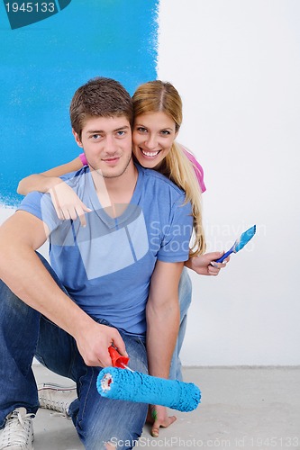 Image of happy couple paint wall at new home