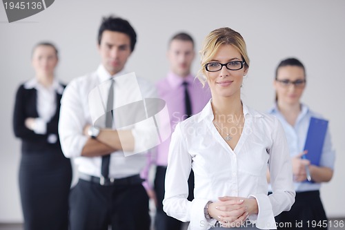 Image of business woman standing with her staff in background