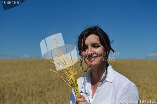 Image of young woman in wheat field at summer