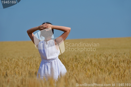 Image of young woman in wheat field at summer