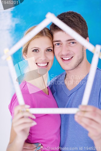 Image of happy couple paint wall at new home