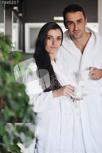 Image of Young love couple taking fresh morning cup of coffee