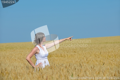 Image of young woman in wheat field at summer