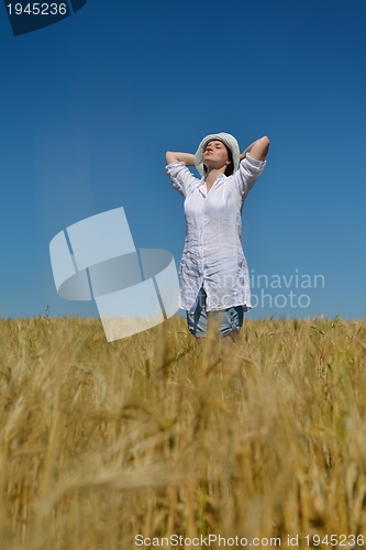 Image of young woman in wheat field at summer
