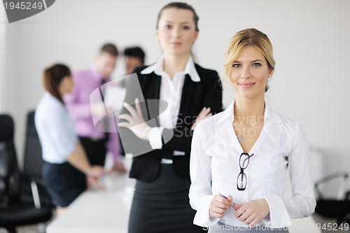 Image of business woman standing with her staff in background