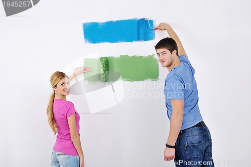 Image of happy couple paint wall at new home